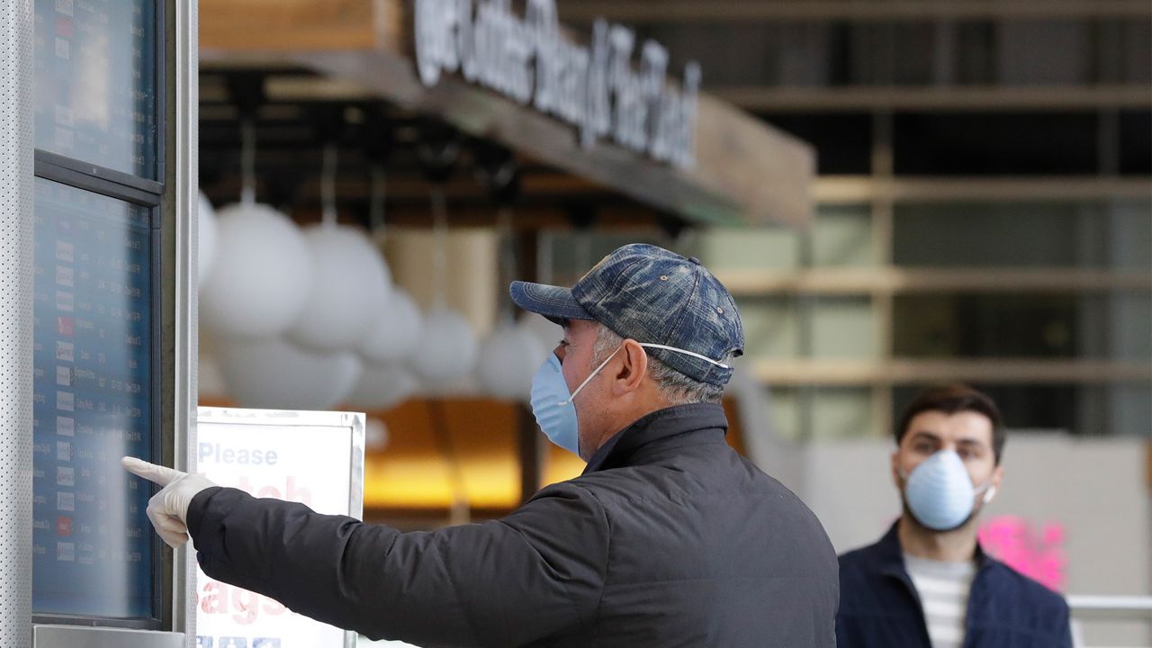 International travelers check flight schedules at the Tom Bradley Terminal at the Los Angeles International Airport, Tuesday, March 24, 2020, in Los Angeles. (AP Photo/Chris Carlson)