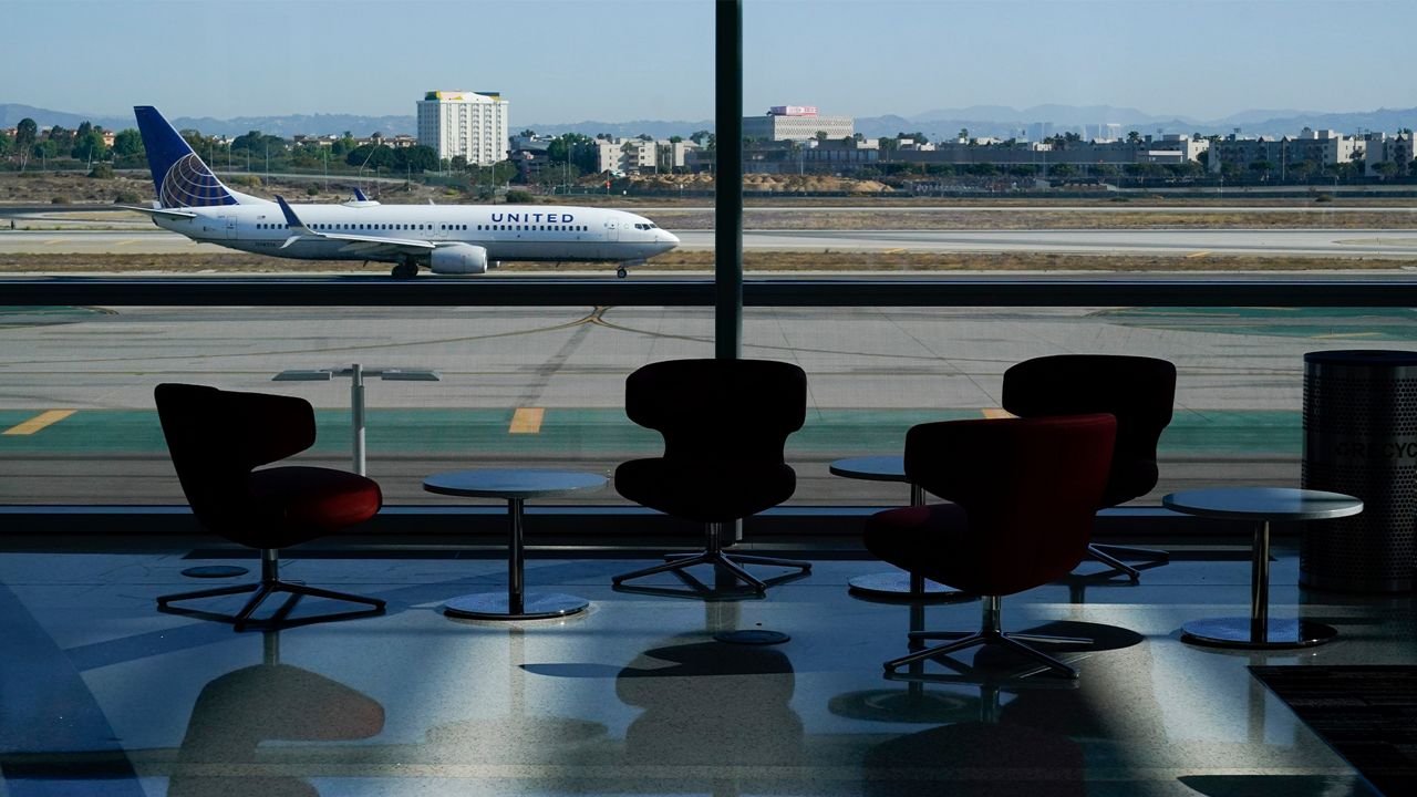 An airplane taxis past a gate at the new West Gates at Tom Bradley International Terminal at Los Angeles International Airport Monday, May 24, 2021, in Los Angeles. (AP Photo/Ashley Landis)