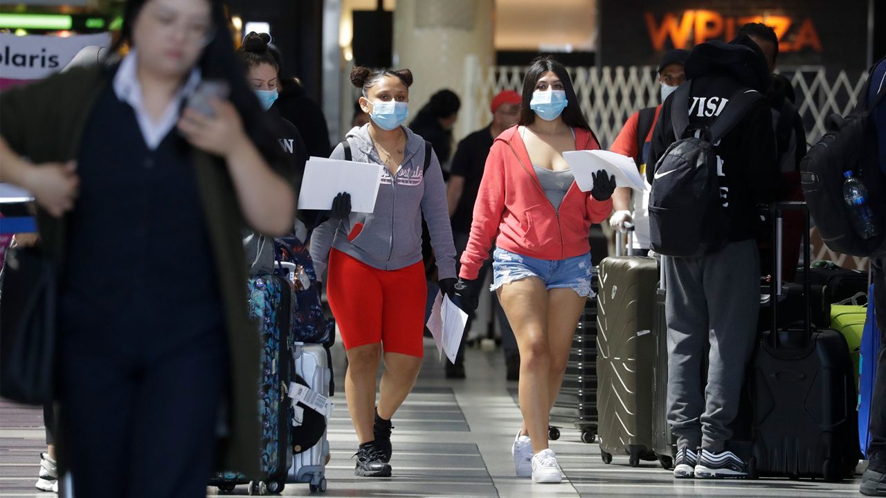 International travelers make their way around the Tom Bradley Terminal at the Los Angeles International Airport, Tuesday, March 24, 2020, in Los Angeles. (AP Photo/Chris Carlson)