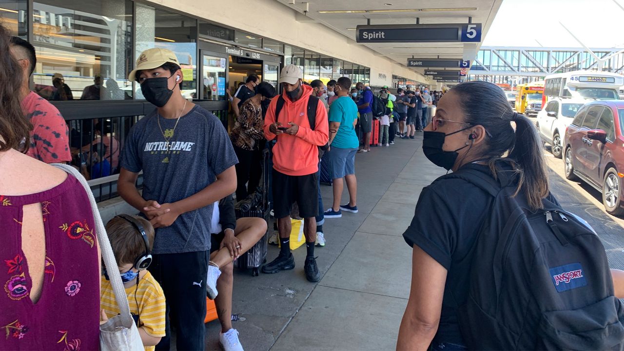 In this Aug. 3, 2021, file photo, passengers line up outside the Spirit Airlines terminal at Los Angeles International Airport in Los Angeles. (AP Photo/Eugene Garcia)