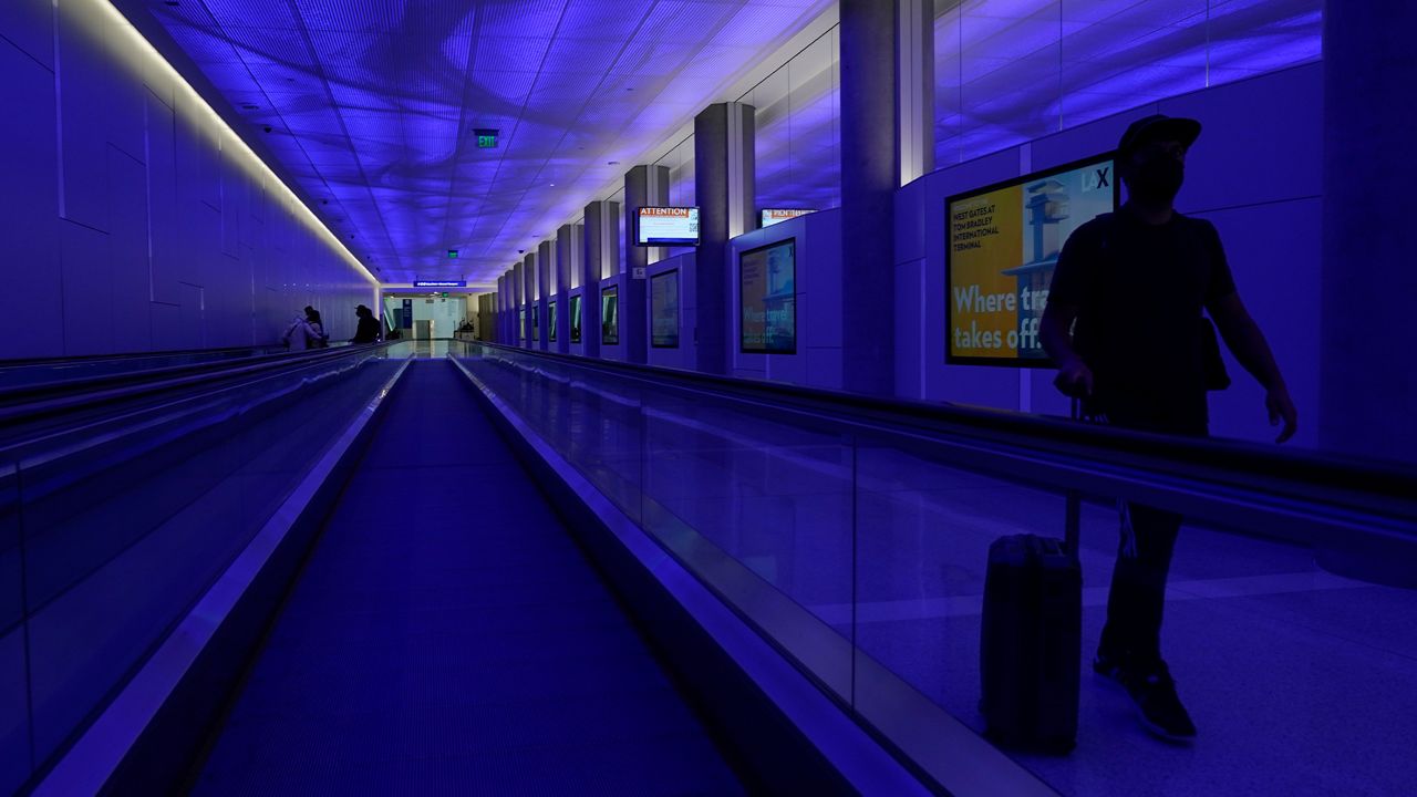 A traveler walks through the passenger tunnel at the new West Gates at Tom Bradley International Terminal at Los Angeles International Airport Monday, May 24, 2021, in Los Angeles. (AP Photo/Ashley Landis)