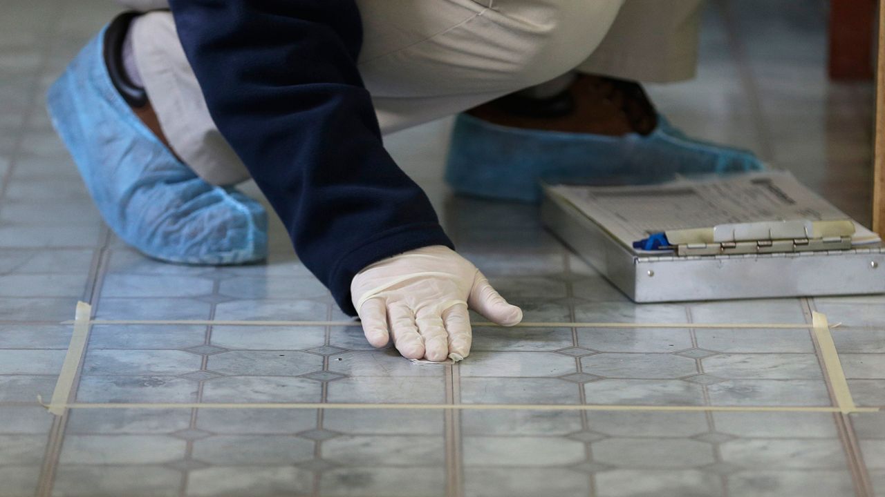 A lead risk assessor checks a kitchen floor for lead. (AP Photo)