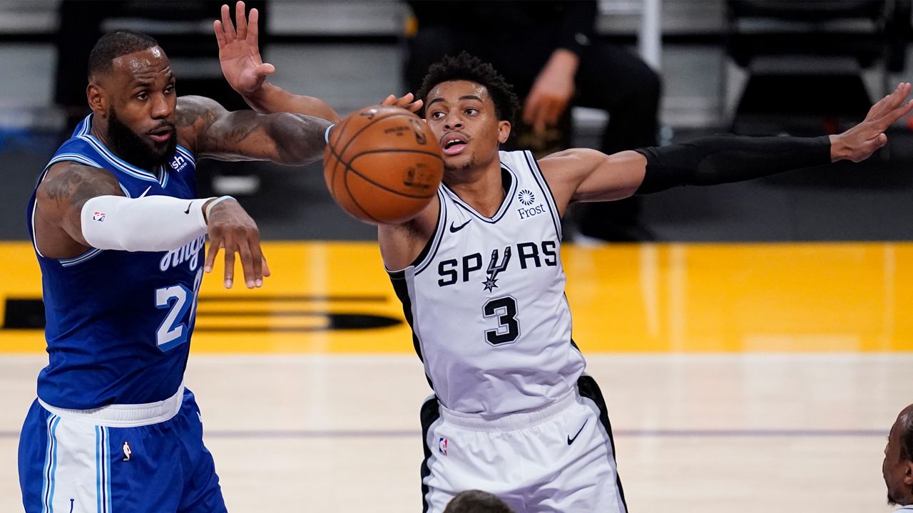 Los Angeles Lakers forward LeBron James, left, passes the ball away from San Antonio Spurs guard Keldon Johnson during the second quarter of an NBA basketball game Thursday, Jan. 7, 2021, in Los Angeles. (AP Photo/Ashley Landis)