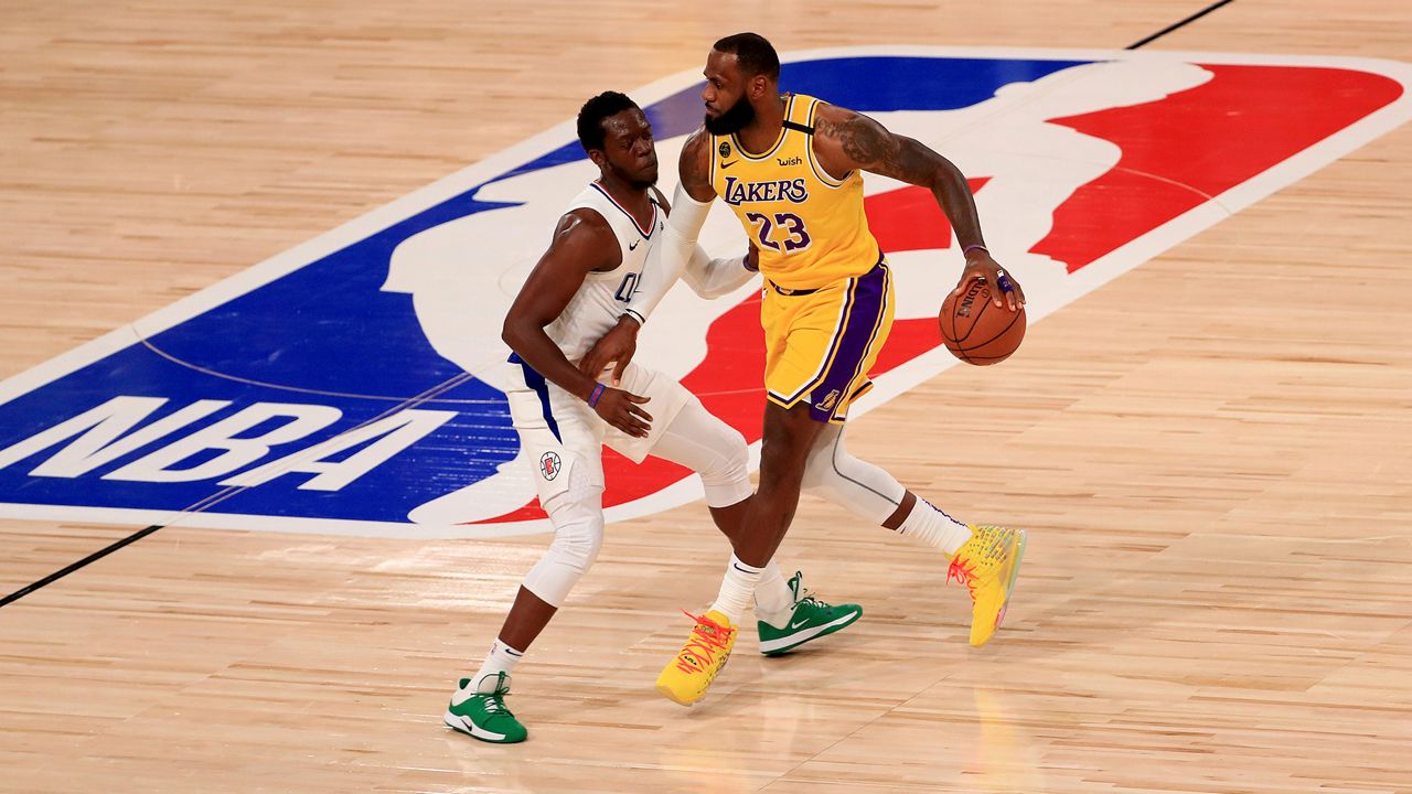 Los Angeles Lakers' LeBron James (23) dribbles the ball against Los Angeles Clippers' Reggie Jackson during the first quarter of an NBA basketball game Thursday, July 30, 2020, in Lake Buena Vista, Fla. (Mike Ehrmann/Pool Photo via AP)