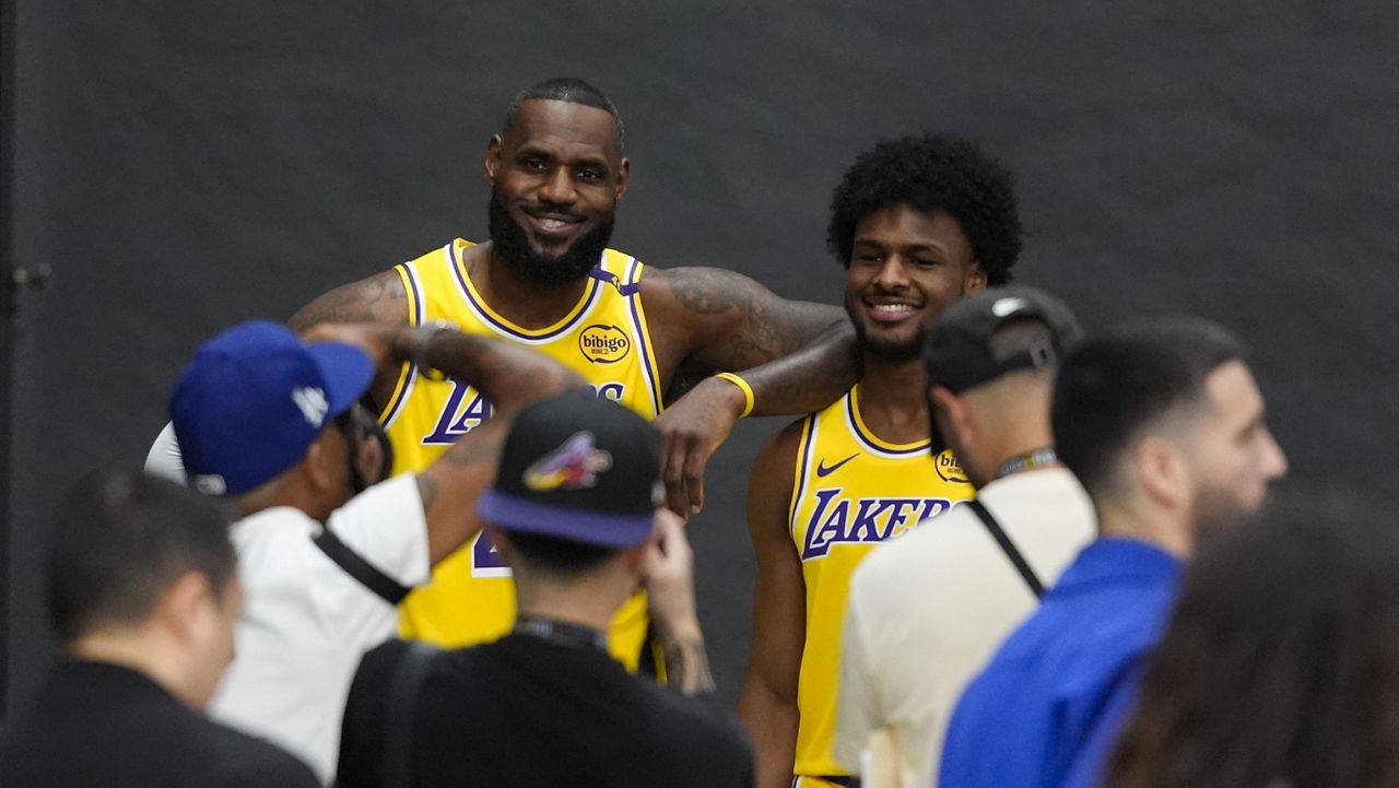 Los Angeles Lakers' LeBron James, left, and his son, Bronny James, pose for photos during the NBA basketball team's media day in El Segundo, Calif., Monday, Sept. 30, 2024. (AP Photo/Jae C. Hong)