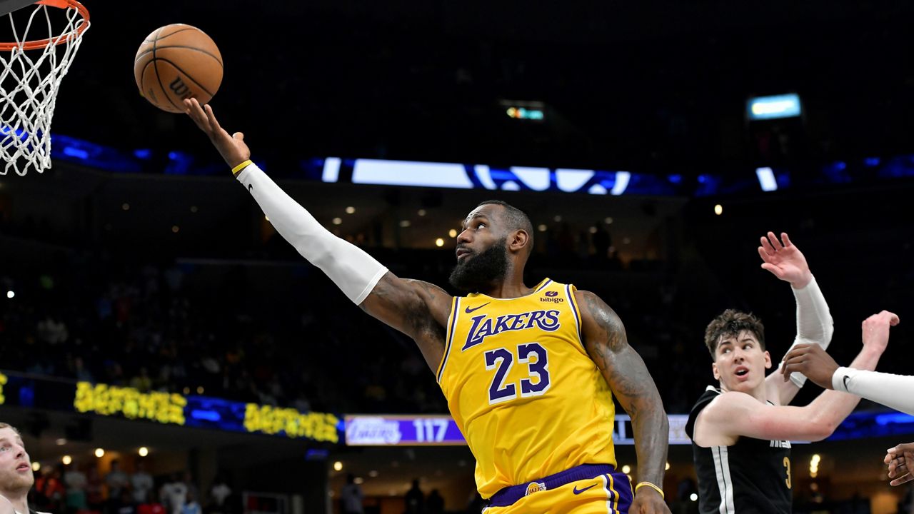 Los Angeles Lakers forward LeBron James (23) shoots next to Memphis Grizzlies forward Jake LaRavia (3) during the second half of an NBA basketball game Friday, April 12, 2024, in Memphis, Tenn. (AP Photo/Brandon Dill)