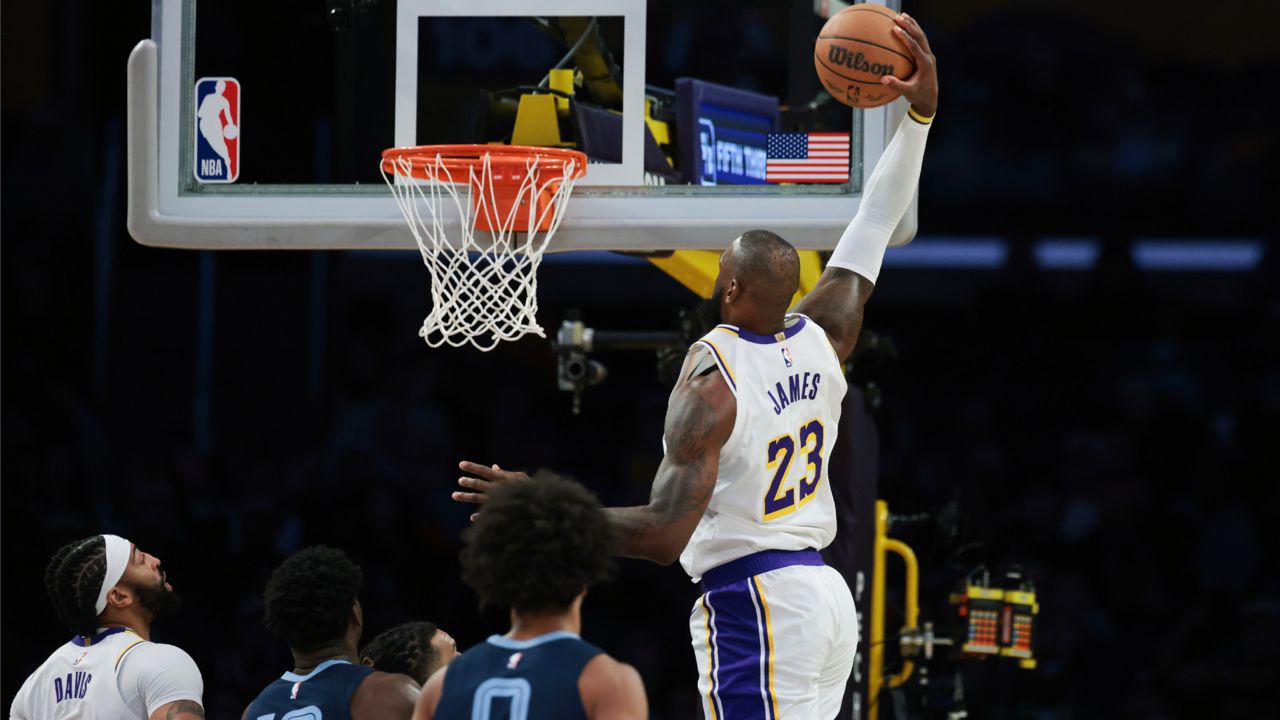 Los Angeles Lakers forward LeBron James (23) dunks the ball as forward Anthony Davis (3), Memphis Grizzlies forward Jaren Jackson Jr. (13) and forward Jaylen Wells (0) watch during the first half of an NBA basketball game Sunday in LA. (AP Photo/Jessie Alcheh)