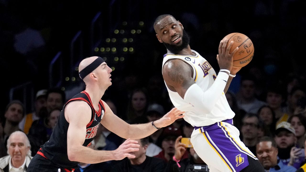 Los Angeles Lakers forward LeBron James, right, is defended by Chicago Bulls guard Alex Caruso during the first half of an NBA basketball game, Sunday, March 26, 2023, in Los Angeles. (AP Photo/Marcio Jose Sanchez)