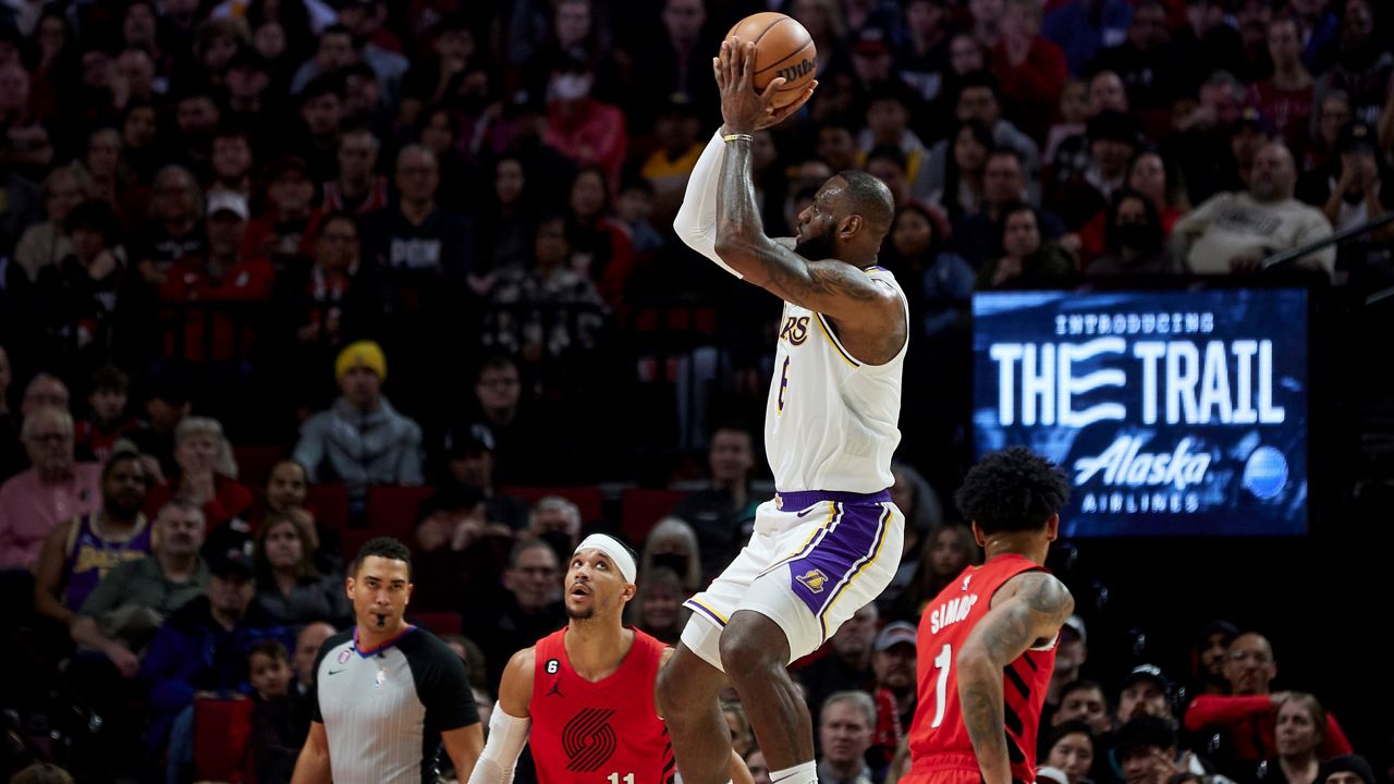 Los Angeles Lakers guard Patrick Beverley, right, shoots while being fouled by Portland Trail Blazers guard Damian Lillard during the second half of an NBA basketball game in Portland, Ore., Sunday, Jan. 22, 2023. (AP Photo/Craig Mitchelldyer)