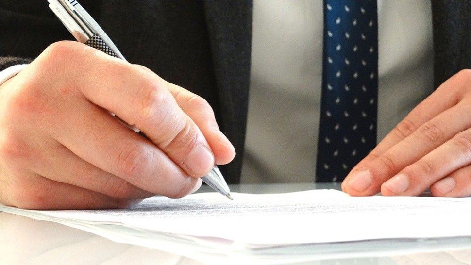 An attorney signs a document in this stock image. (Pixabay)