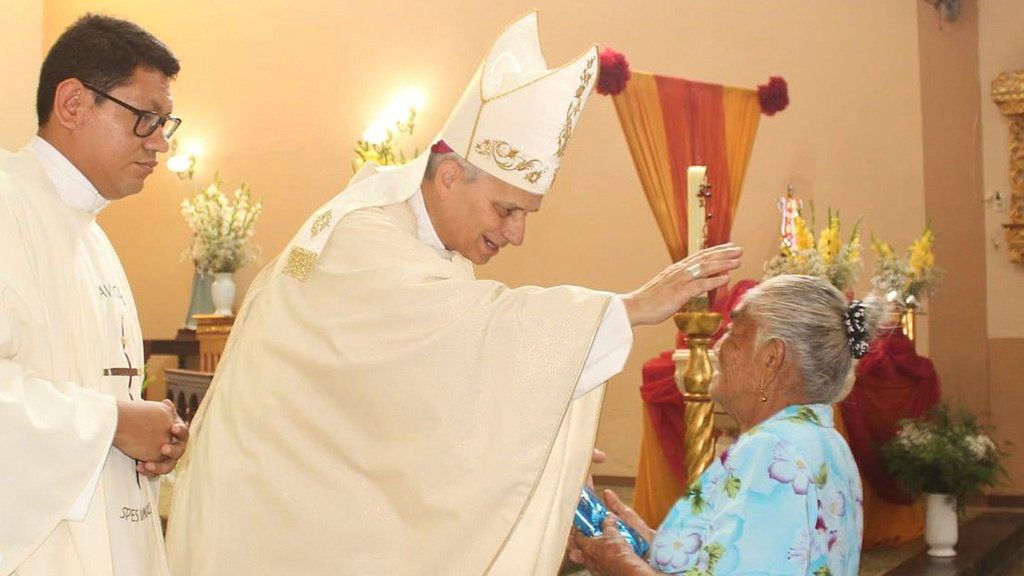 En esta foto difundida por la Hermandad Cruz de Motupe, el obispo Robert Prevost, elegido Papa León XIV, bendice a una mujer durante una misa en Motupe, Perú, en septiembre de 2020. 