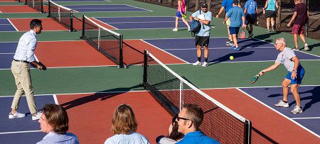 Cincinnati Mayor Aftab Pureval (left) prepares to return a shot from Gary Lessis (right) during a ribbon-cutting for the largely city-funded renovation project. (Photo courtesy of Gary Lessis)