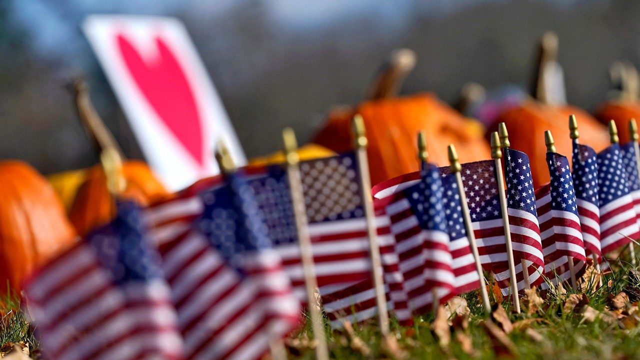 Pumpkins and flags line the curbside outside Sparetime Bowling, Friday, Nov. 3, Lewiston, Maine, prior to the arrival of President Joe Biden. (AP Photo/Matt York)