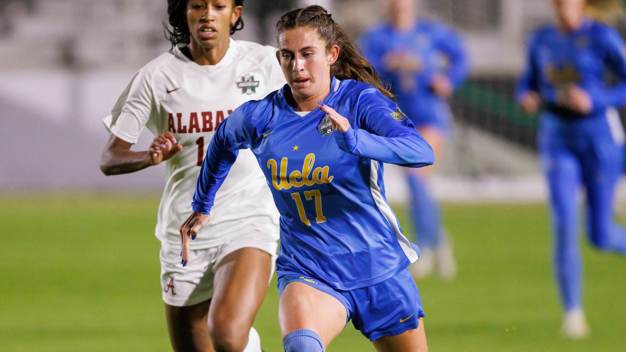 UCLA's Lexi Wright (17) works with the ball in front of Alabama's Gianna Paul during the first half of an NCAA women's soccer tournament semifinal in Cary, N.C., Friday, Dec. 2, 2022. (AP Photo/Ben McKeown)