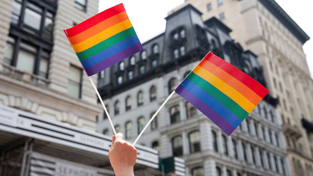 An attendee holds up flags during the New York City Pride Parade, June 24, 2018, in New York. (AP Photo/Steve Luciano, File)