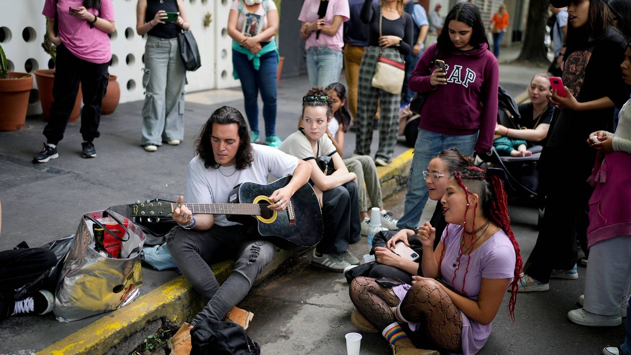 Fans sing in honor of former One Direction singer Liam Payne outside the hotel where he was found dead after falling from a balcony in Buenos Aires, Argentina, Thursday, Oct. 17, 2024. (AP Photo/Natacha Pisarenko)