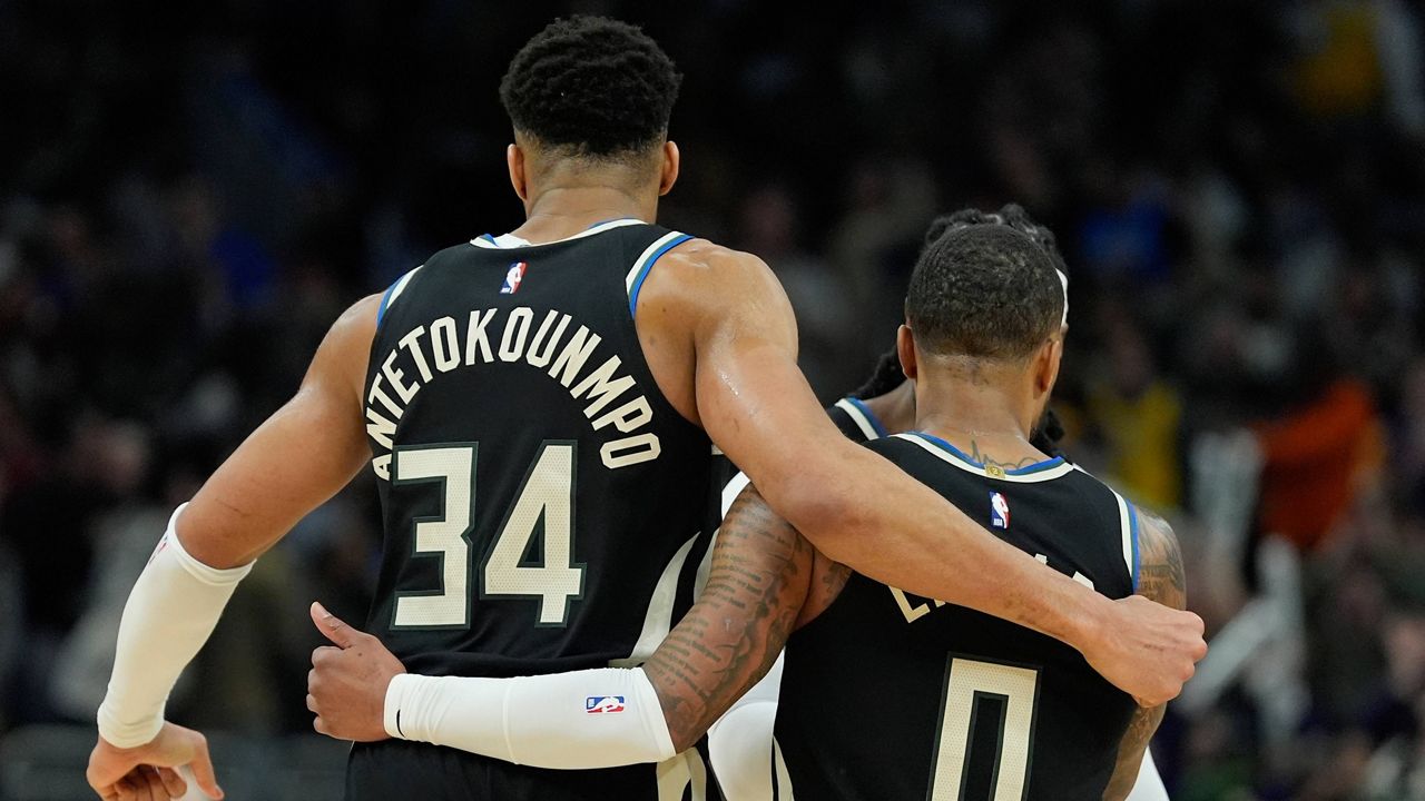 Giannis Antetokounmpo hugs Damian Lillard 