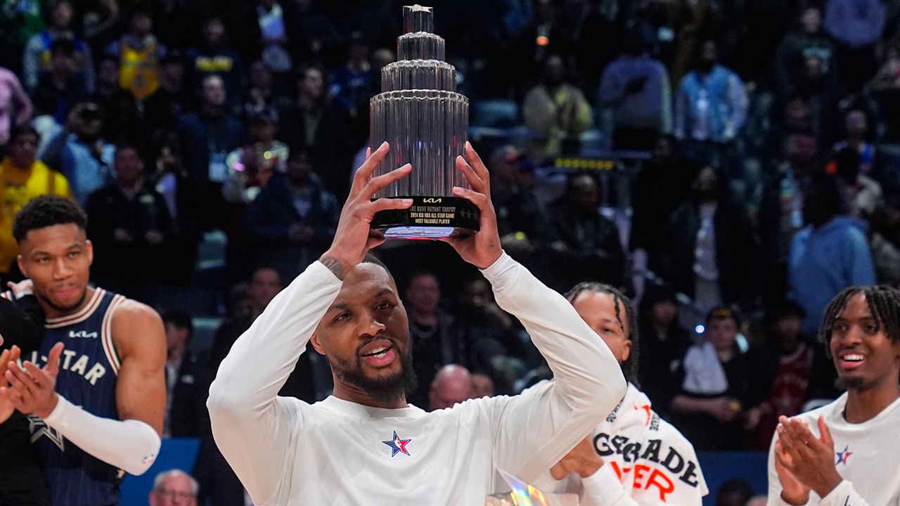 Milwaukee Bucks guard Damian Lillard (0) lifts the MVP trophy 