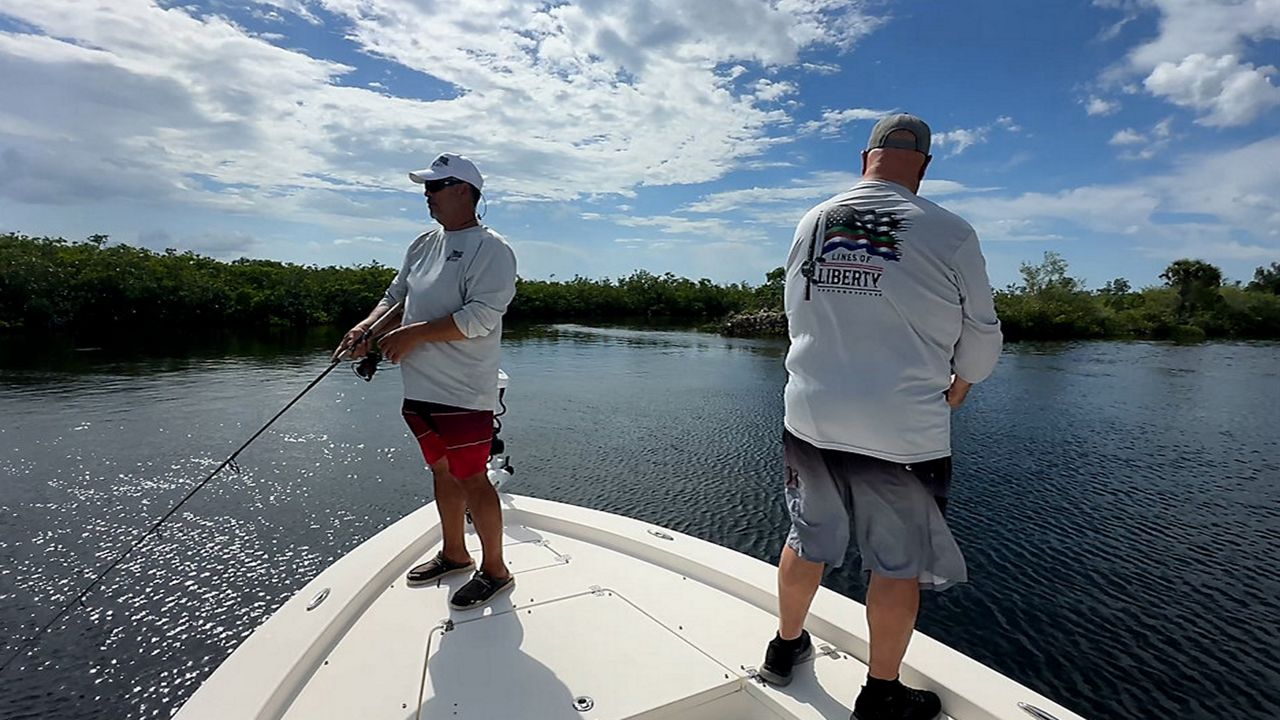 Members of Lines of Liberty take some time to relax and fish on their boat. (Spectrum News/Matt Lackritz)