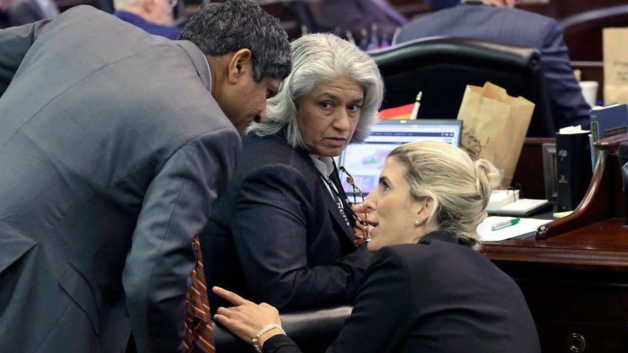 Sen. Jay Chaudhuri, D-Wake, left, Sen. Lisa Grafstein, D-Wake, center, and Sen. Mary Wills Bode, D-Granville, right, confer as the N.C. Senate debates redistricting bills at the Legislative Building on Tuesday, Oct. 24, 2023, in Raleigh, N.C. (AP Photo/Chris Seward)
