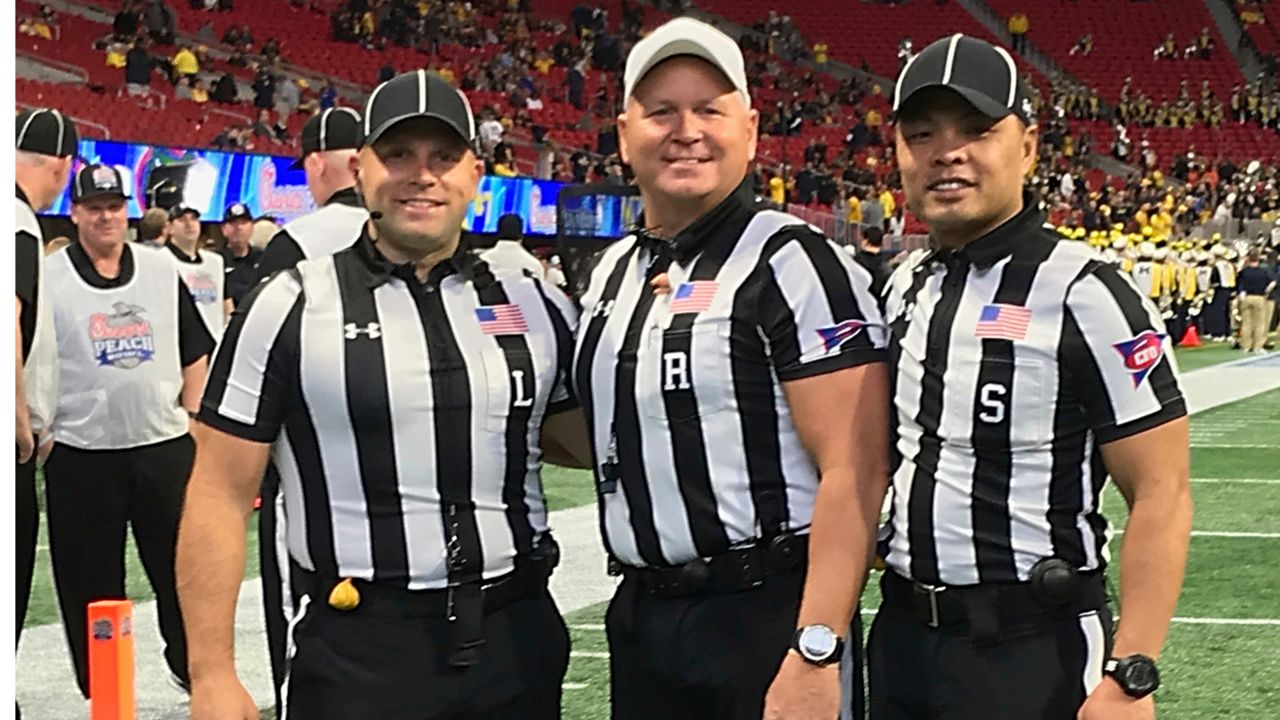 In this Dec. 29, 2018 photo provided by Lo van Pham, from left, line judge Derek Anderson, referee Mike Defee and side judge Lo van Pham pose for a photo before the Peach Bowl NCAA college football game in Atlanta. Lo van Pham’s journey to the NFL began when he fell in love with sports upon arriving in Texas after living in refugee camps with his family. More than 40 years later, van Pham is set to become the first Asian American to officiate in the NFL. (Lo van Pham/NFL via AP)