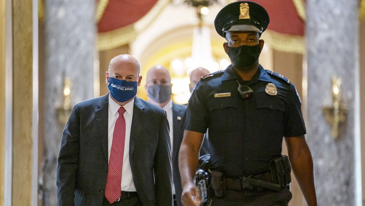 In this Aug. 5, 2020, file photo Postmaster General Louis DeJoy, left, is escorted to House Speaker Nancy Pelosi's office on Capitol Hill in Washington. 