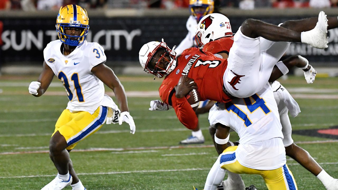 Louisville quarterback Malik Cunningham (3) is flipped as he is tackled by Pittsburgh defensive back Marquis Williams (14) during the first half of an NCAA college football game in Louisville, Ky., Saturday, Oct. 22, 2022. (AP Photo/Timothy D. Easley)