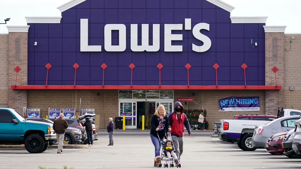 Shoppers walk in the lot of a Lowe's home improvement store in Philadelphia, Wednesday, Nov. 17, 2021. The home improvement company is teaming up with Petco to offer pet departments within its stores. (AP Photo/Matt Rourke)