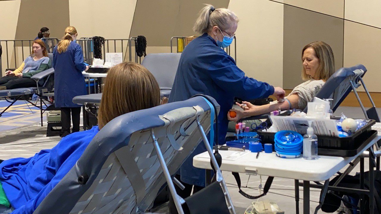 Lynn English looks at her arm as she prepares to give blood with her former colleague Kara Lee. (Spectrum News 1/Diamond Palmer)