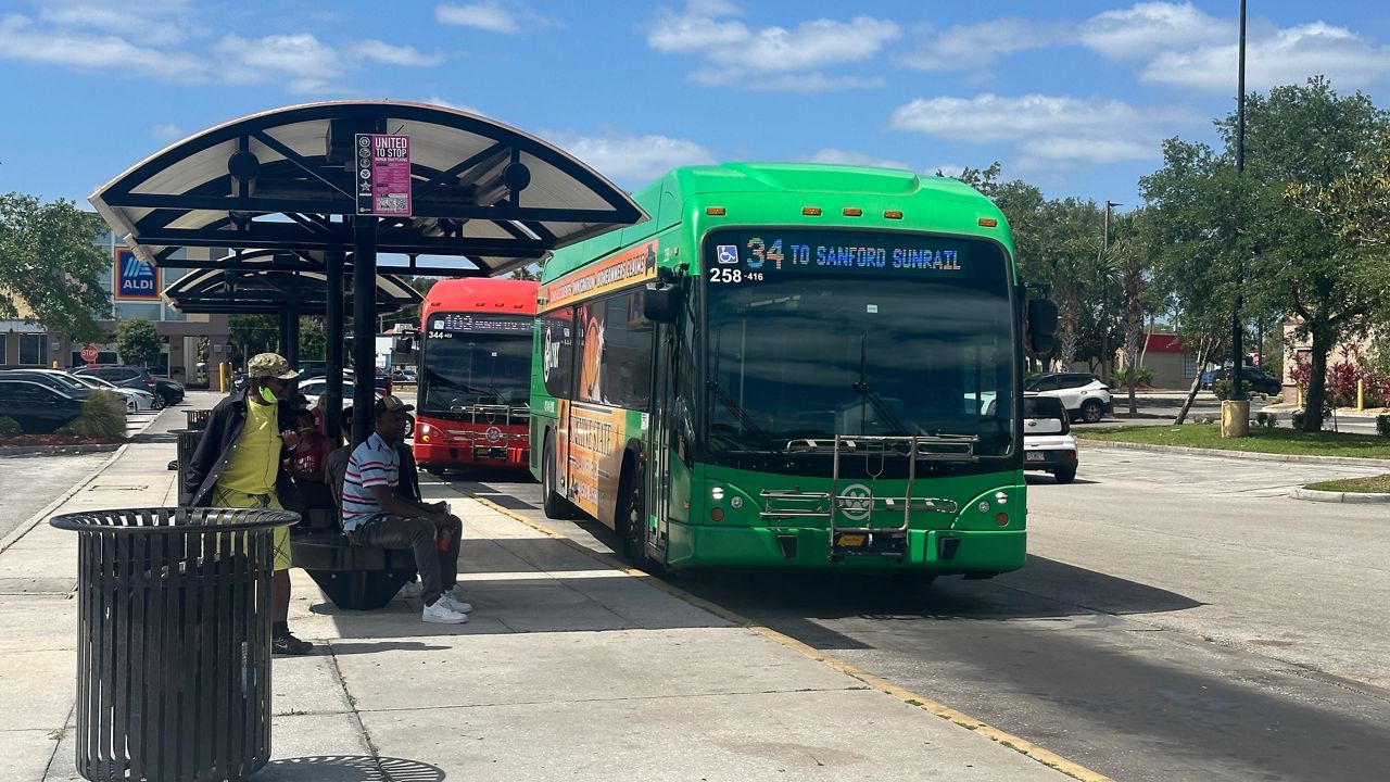 Residents wait at a Lynx bus stop in Seminole County. (Spectrum News/Massiel Leyva)