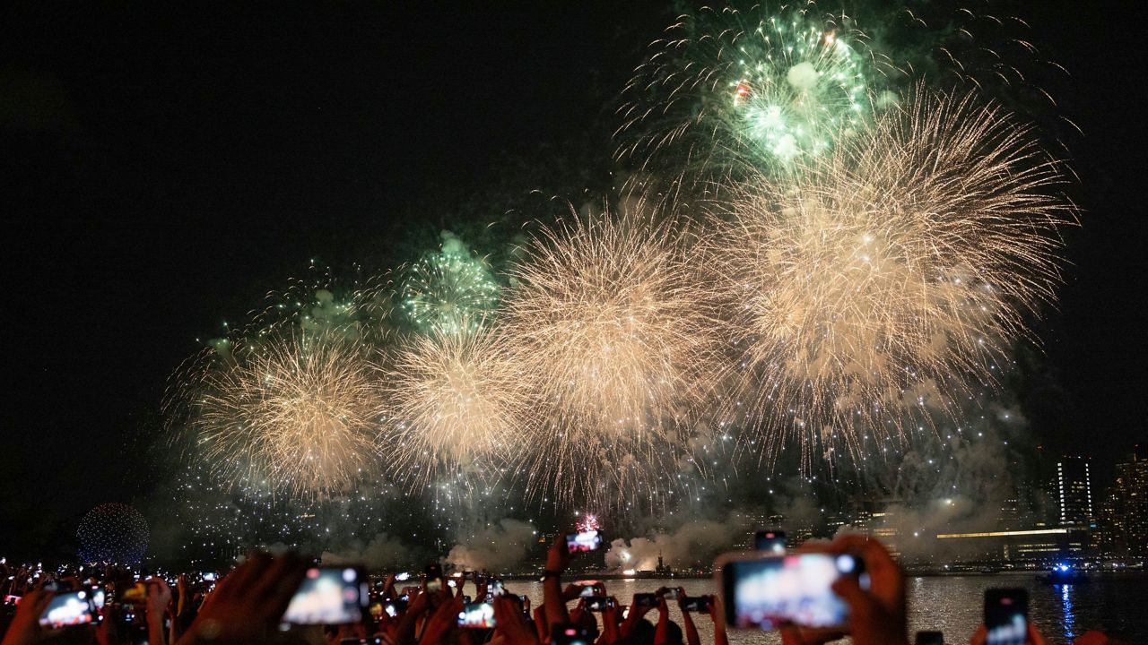 People watch the Macy's Fourth of July fireworks in New York on Tuesday, July 4, 2023.