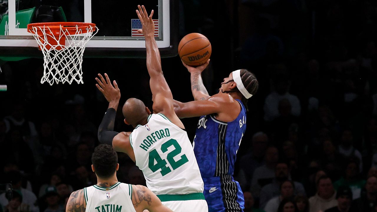 Orlando Magic forward Paolo Banchero, right, drives to the basket ahead of Boston Celtics center Al Horford (42) and forward Jayson Tatum (0) during the first half of an NBA basketball game, Sunday, Dec. 17, 2023, in Boston. (AP Photo/Mary Schwalm)