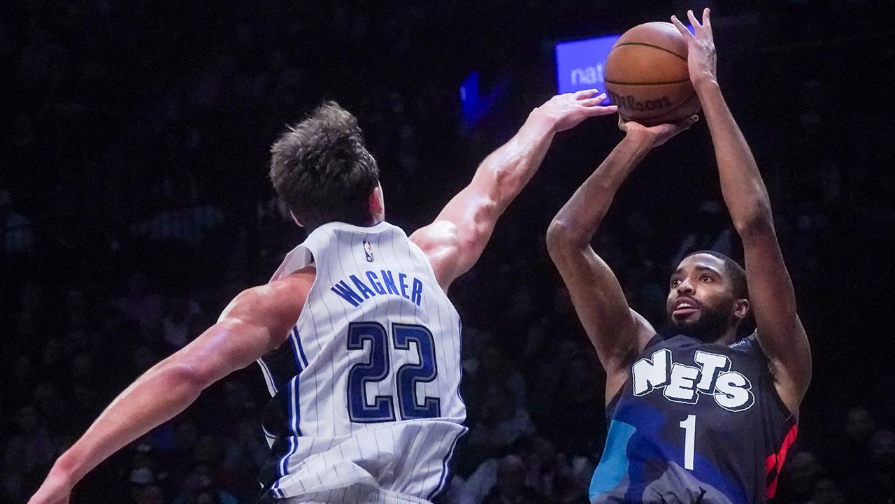 Brooklyn Nets forward Mikal Bridges, right, shoots over Orlando Magic's Franz Wagner, left, during the fourth period of an NBA basketball game, Saturday, Dec. 2, 2023, in New York. (AP Photo/Bebeto Matthews)