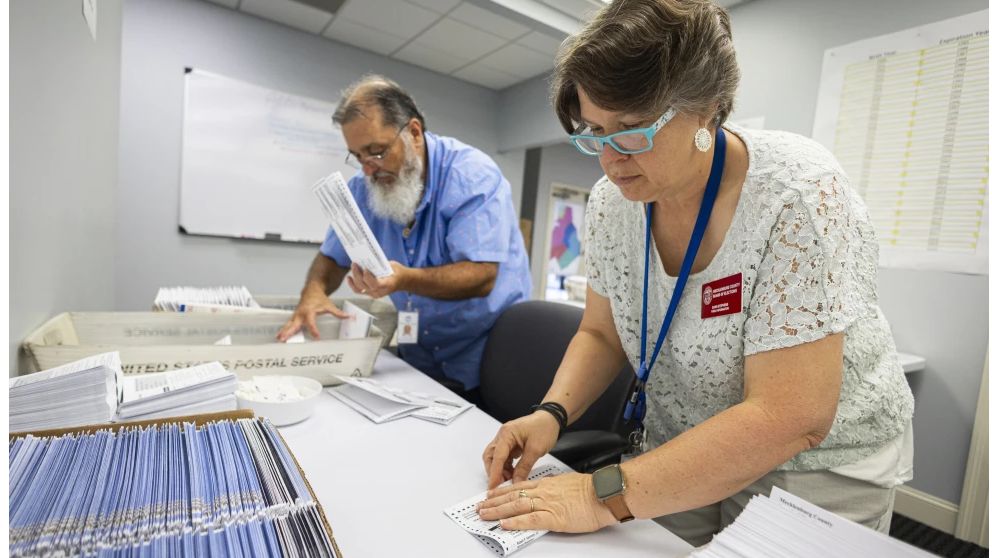 Dawn Stephens, right, and Duane Taylor prepare ballots to be mailed at the Mecklenburg County Board of Elections in Charlotte, N.C., Thursday, Sept. 5, 2024. (AP Photo/Nell Redmond)