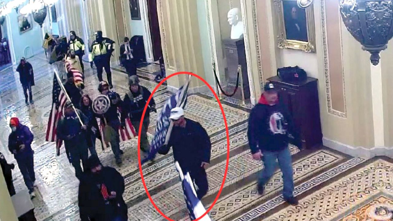 A man believed to be Steve Omar Maldonado is seen carrying a blue Trump flag inside the U.S. Capitol on January 6. (U.S. District Court for the District of Columbia)