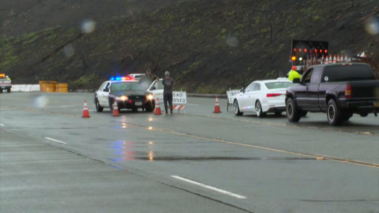 A police car on a Malibu road that's closed due to weather conditions.
