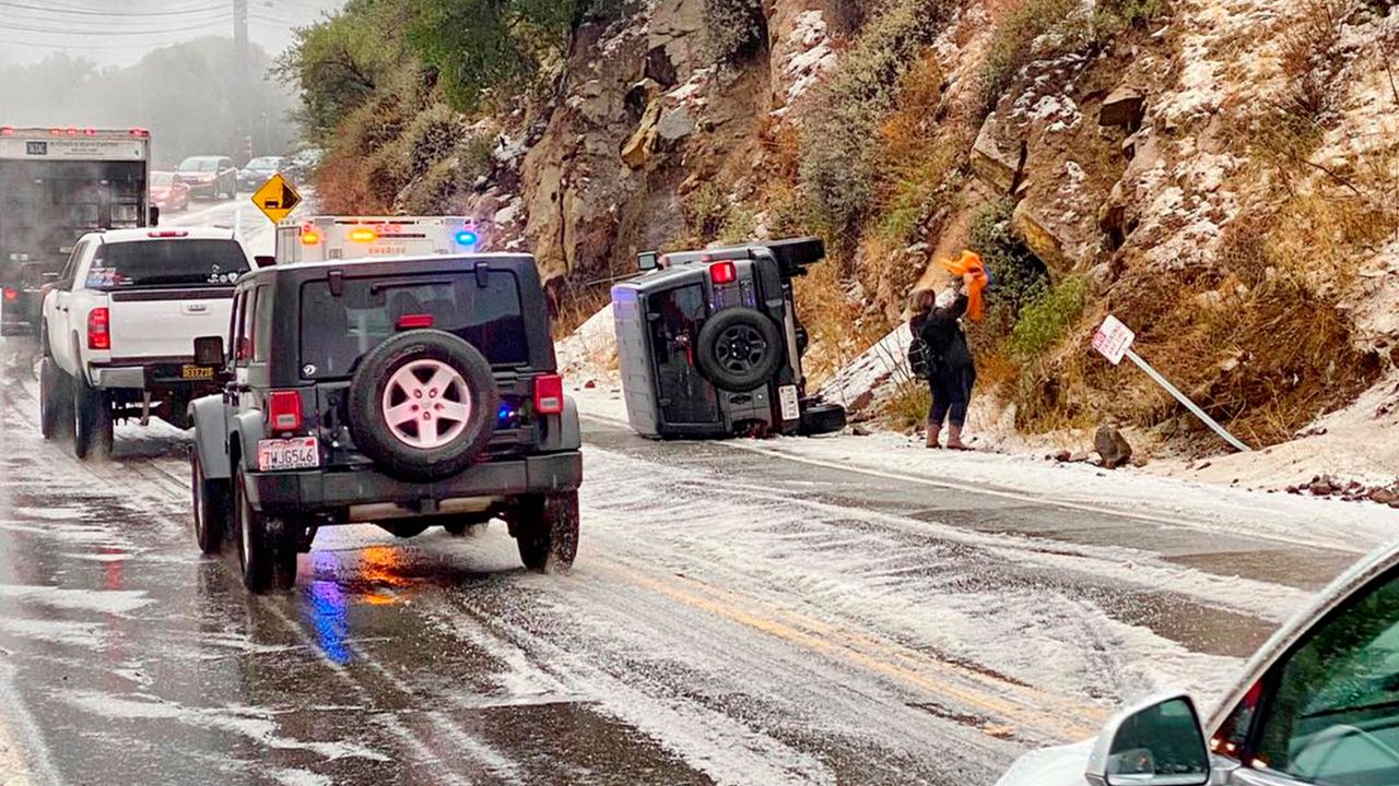 In this Saturday, Jan. 23, 2021, photo provided by the California Highway Patrol-West Valley, authorities work the scene of an accident after a hail storm on Malibu Canyon Road in Malibu, Calif. (California Highway Patrol via AP)