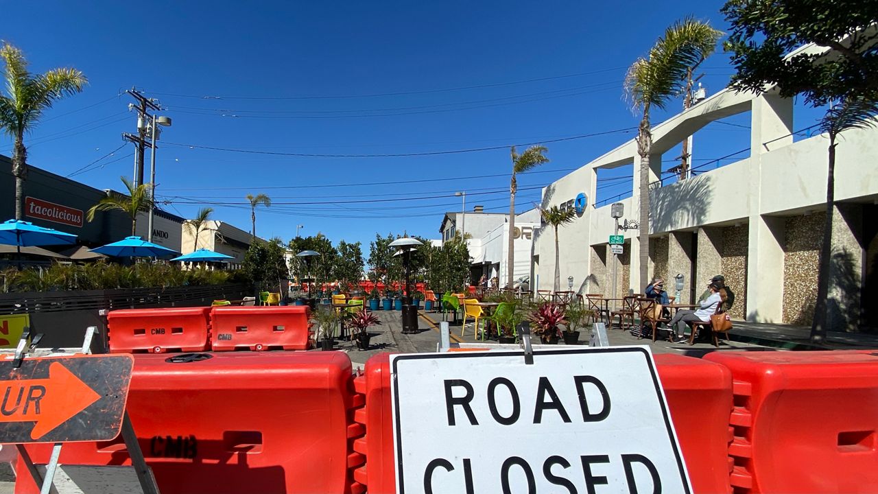 Barriers separate pedestrians and residents from the road in downtown Manhattan Beach, as the city tries a temporary road closure program. (Spectrum News/David Mendez)