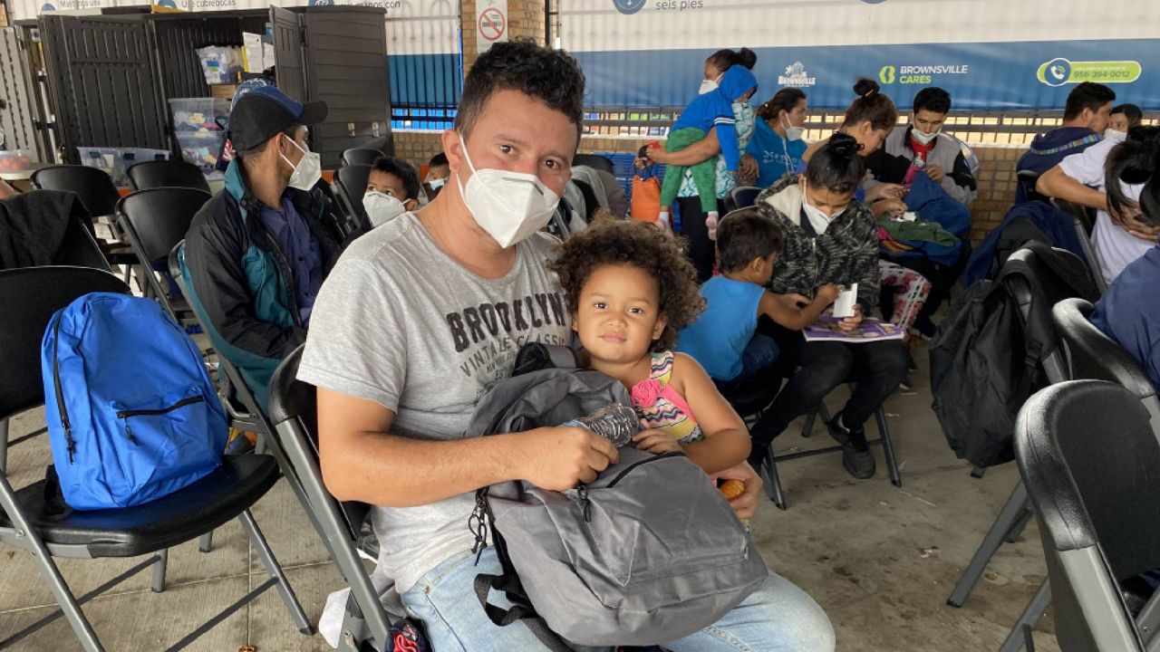 Manuel Martinez, 27, and his daughter Leah, 4, wait for a bus in Brownsville, Texas. They're one of an increasing number of families that is being processed at the border instead of expelled under a public health order. (Sabra Ayres for Spectrum News)