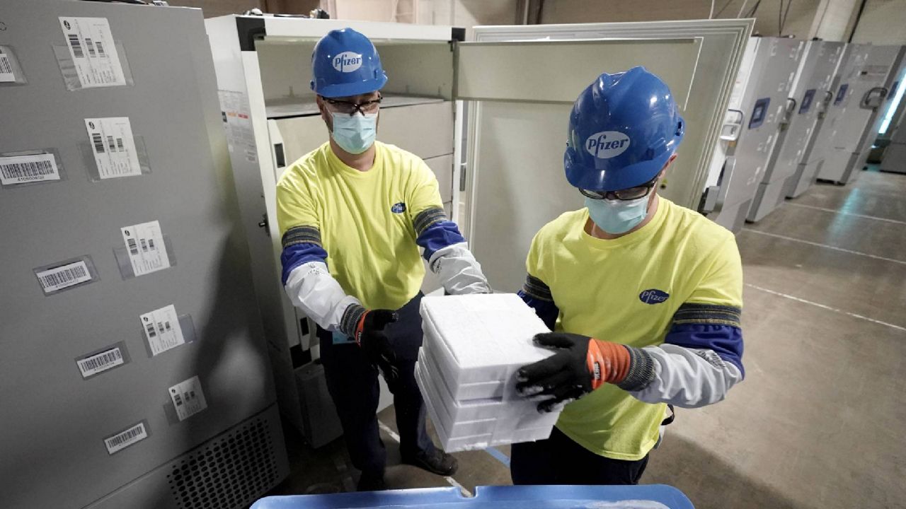 FILE - Boxes containing the Pfizer-BioNTech COVID-19 vaccine are prepared to be shipped at the company’s Michigan plant. Manufacturing workers could be included in the group of essential workers prioritized for the next phase of coronavirus vaccinations. (AP Photo/Morry Gash, Pool, File)