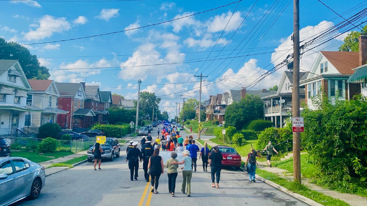 Dozens of marchers take part in a 'peace walk' to promote an end to gun violence in Cincinnati's Evanston neighborhood. (Casey Weldon/Spectrum News 1)