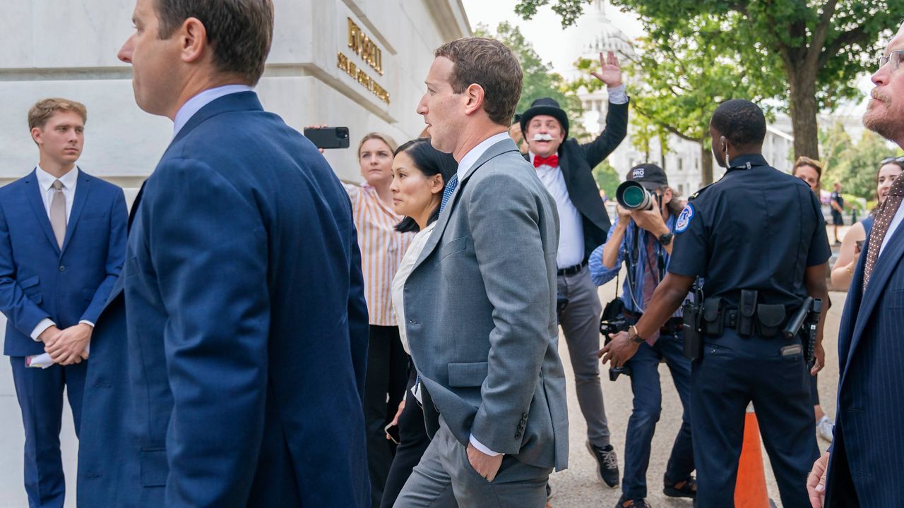 Meta CEO Mark Zuckerberg passes media and a protester as he arrives for a closed-door gathering of leading tech CEOs to discuss the priorities and risks surrounding artificial intelligence, on Capitol Hill in Washington, on Sept. 13, 2023. (AP Photo/Jacquelyn Martin, File)