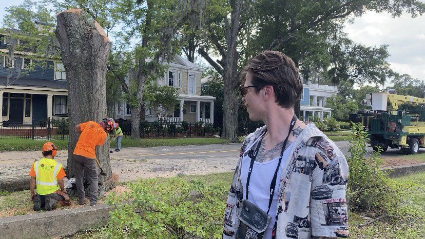 Garion Brodeur watches as a tree is cut down on Market Street. (Spectrum News 1/Natalie Mooney)