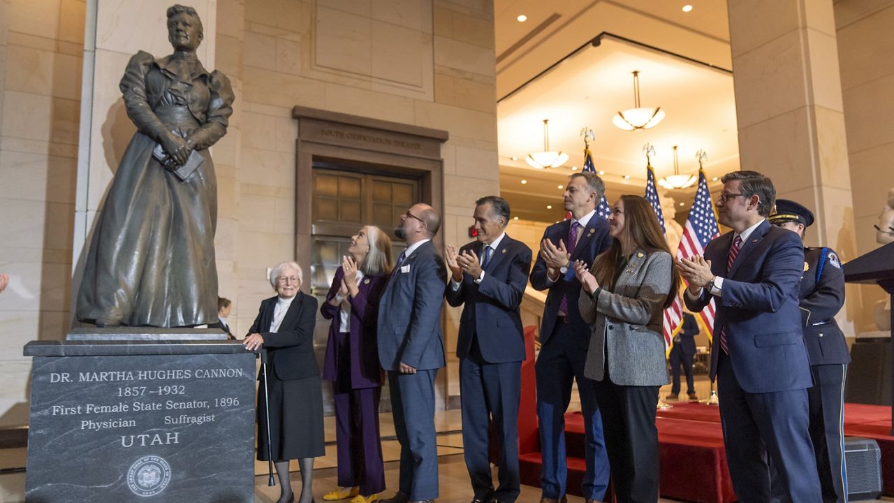 Arline Arnold Brady, left, the great-granddaughter of Martha Hughes Cannon of Utah, House Minority Whip Katherine Clark of Mass., second from left, Sen. Mitt Romney, R-Utah, fourth from left, and House Speaker Mike Johnson of La. applaud after the unveiling a statue of Cannon during a ceremony on Capitol Hill, Wednesday, Dec. 11, 2024, in Washington. (AP Photo/Mark Schiefelbein)