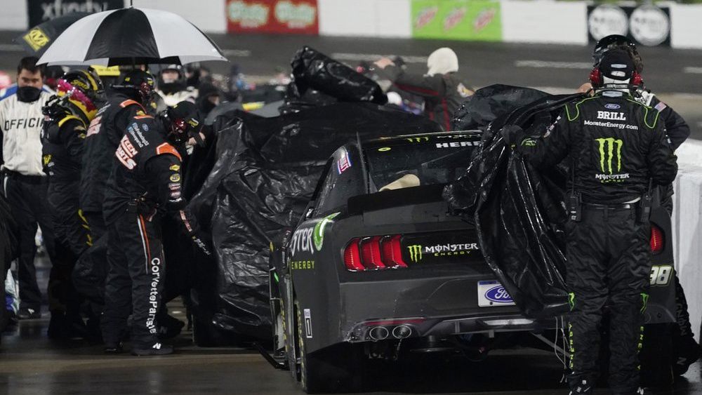 Pit crews cover cars during a rain delay in the NASCAR Xfinity Series auto race at Martinsville Speedway in Martinsville, Va., Friday, April 9, 2021. (AP Photo/Steve Helber)