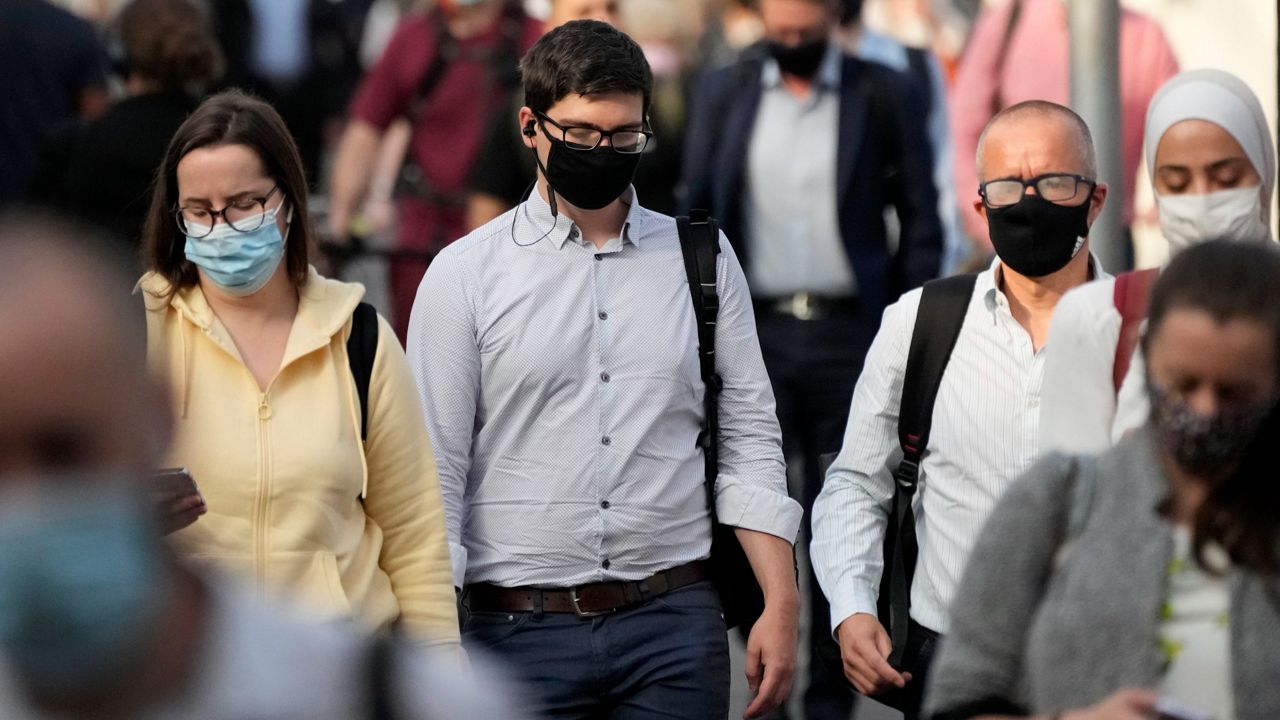 People walking wearing masks. (AP Images)