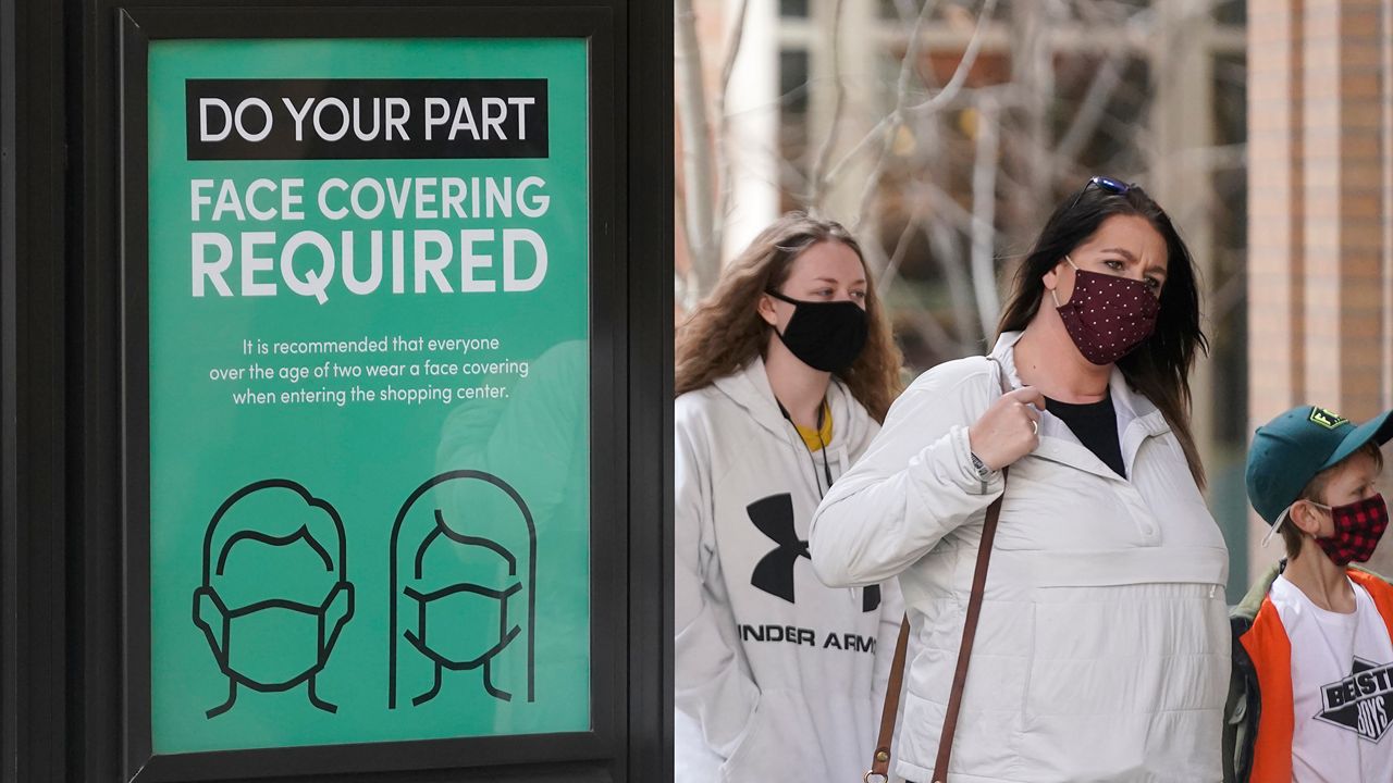 Parents and students walk into school wearing masks. (Associated Press)