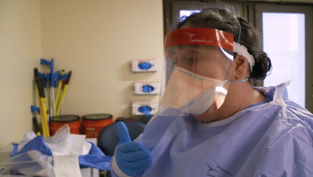 A person wearing a surgical mask and protective gown