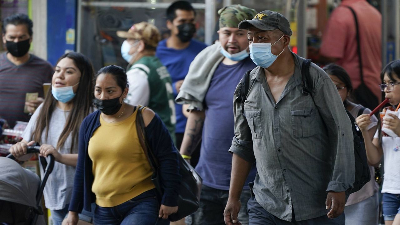 Pedestrians wear masks during the coronavirus pandemic in the Queens borough of New York. (AP Photo/Frank Franklin II, File)