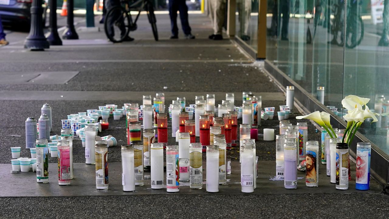Candles and flowers make up a memorial, Tuesday, April 5,2022, at a memorial for those killed and injured in a mass shooting on April 3, 2022, in Sacramento, Calif. (AP Photo/Rich Pedroncelli)
